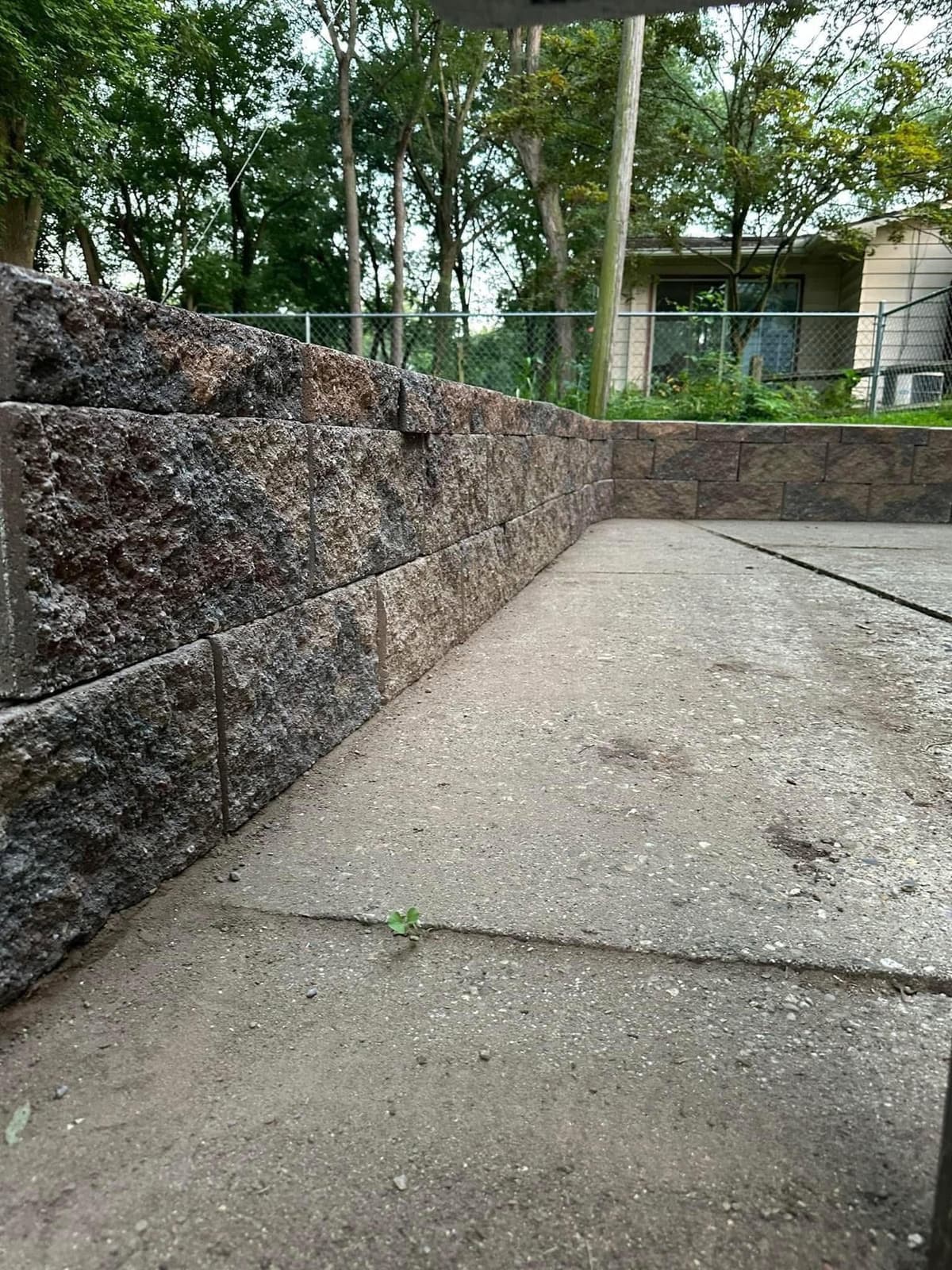 Completed retaining wall project with professional landscaping