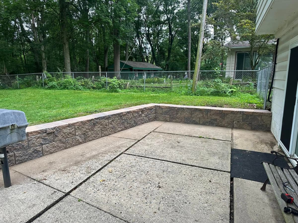 Beautiful stone retaining wall creating usable space in Michigan yard
